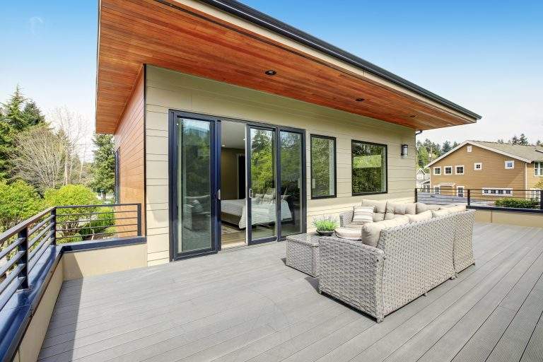 Contemporary deck features a modern wicker sectional facing glass sliding doors of a master bedroom . Northwest, USA